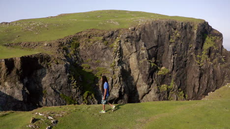 Slow-motion-shot-of-a-man-walking-on-the-edge-of-a-cliff