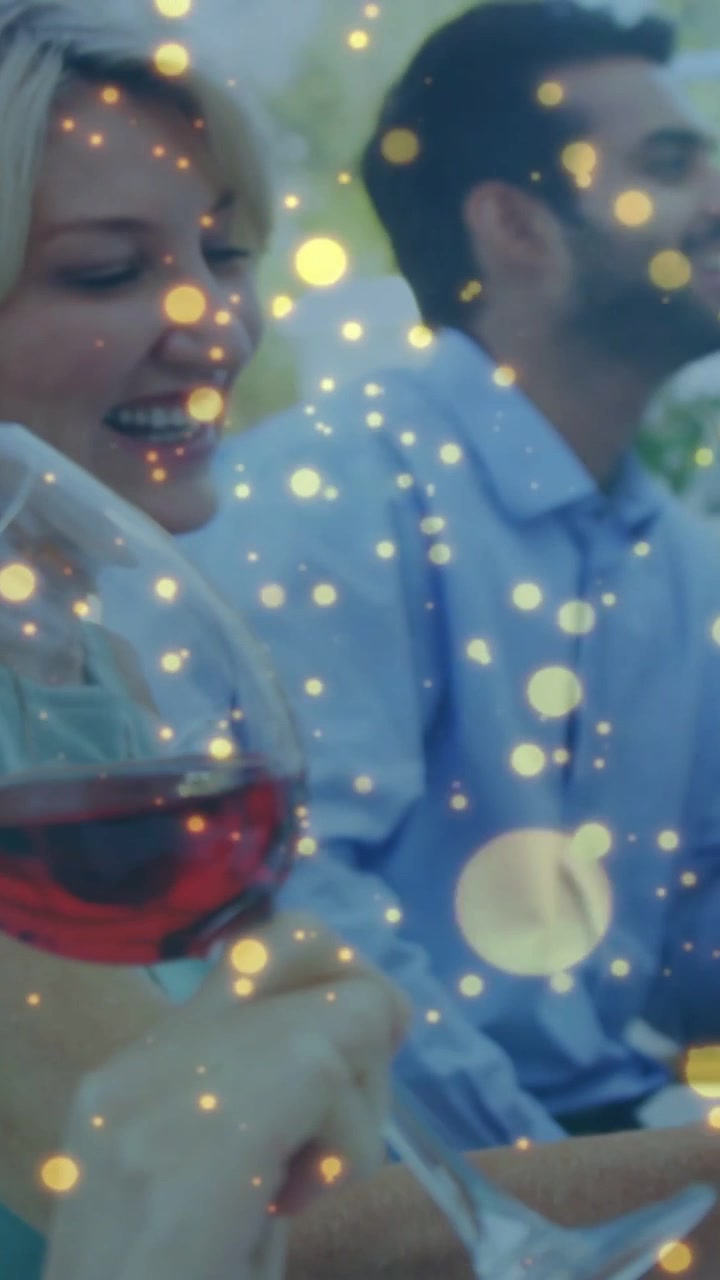 Vertikal video: Kvinde løfter et vinglas, snuser og hvirvler for at nyde aromaen, mens gylden bokeh driver.