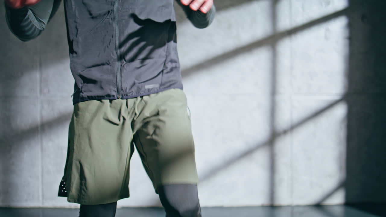 Closeup athlete legs training in loft place. Professional runner body exercising