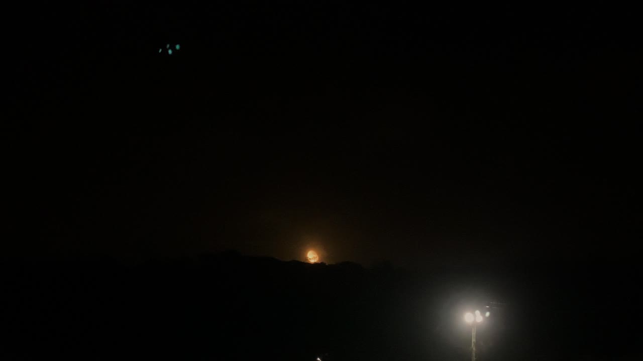 asombrosa vista de la luna moviéndose detrás de la montaña sobre el cielo oscuro en costa da caparica
