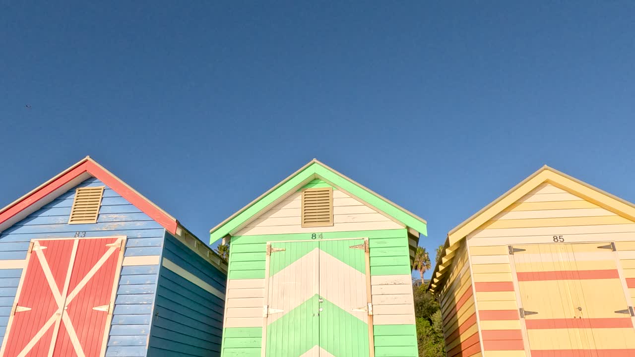 은 파란 하늘 아래 밝게 칠한 해변 오두막