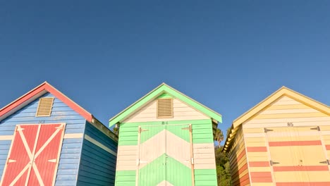 brightly painted beach huts under clear blue sky