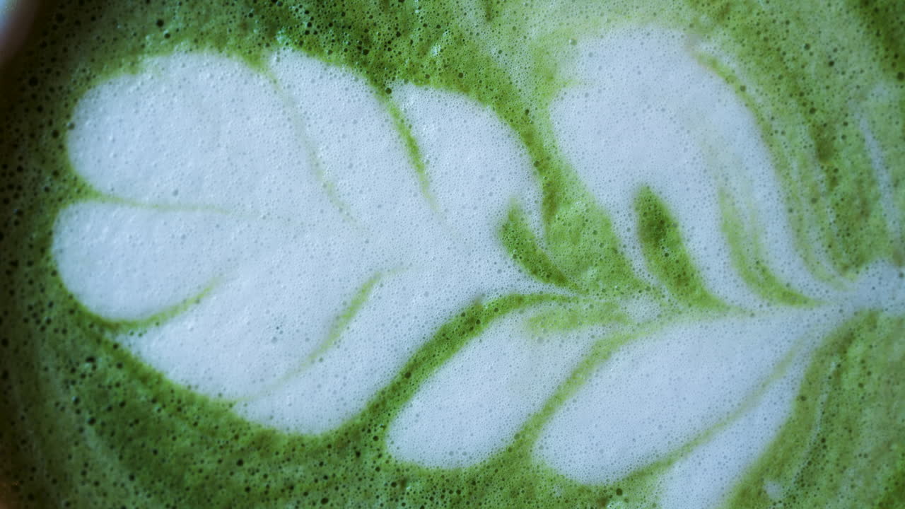 Close up of a matcha latte on a wooden table. Vertical