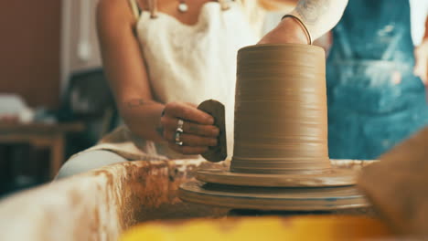 an unrecognisable woman working with clay