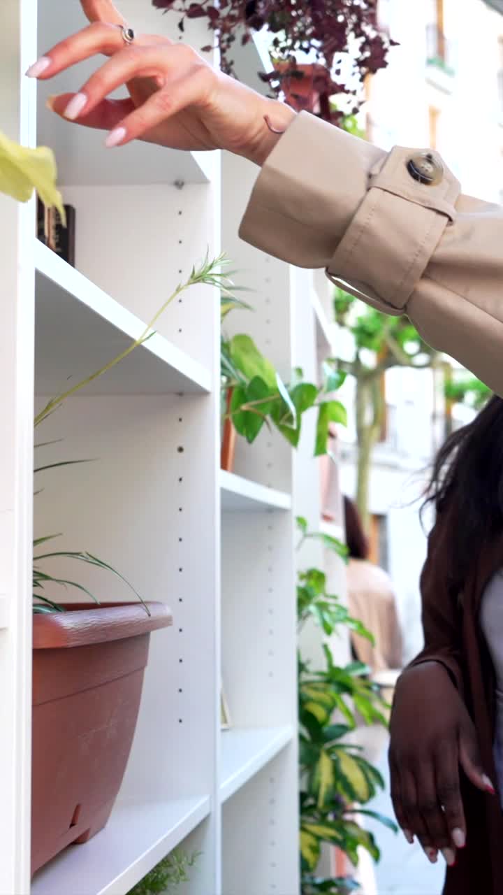 A woman browsing plants on outdoor shelves