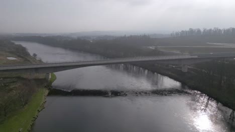 beautiful aerial view of the new destiny bridge over river tay on a sunny spring day. drone ascending camera tilting down