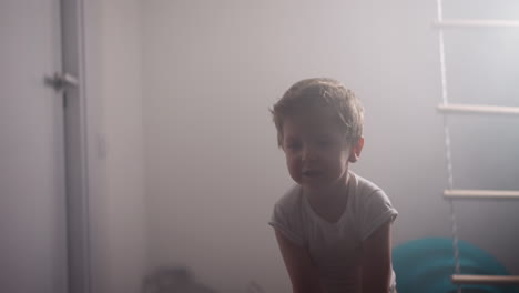 active little boy does effective exercise with battle rope