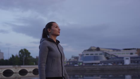 Mujer-Deportiva-Con-Capucha-Caminando-Y-Respirando-Profundamente-Antes-De-Su-Sesión-De-Carrera