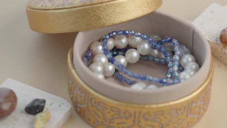 gold jewelry box with pearl and beaded bracelets