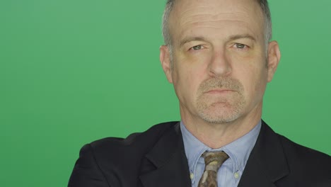 middle aged businessman looking slightly upset, on a green screen studio background