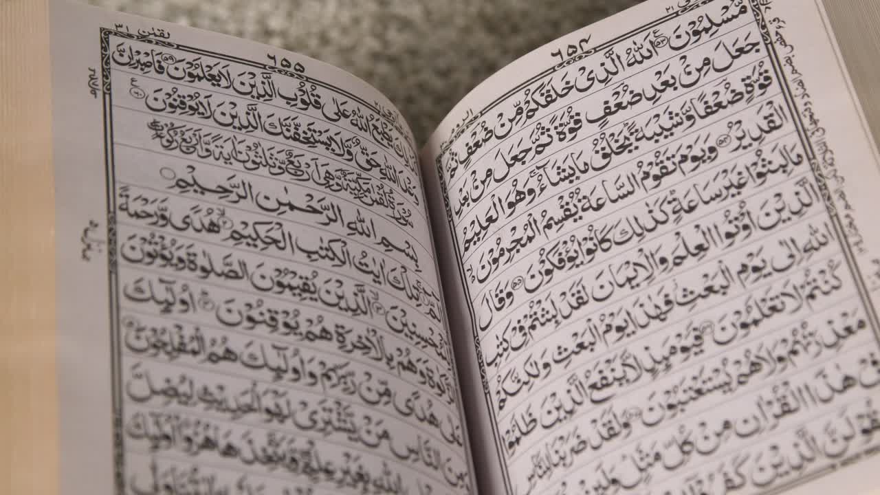 집에 있는 스탠드에 있는 꾸란의 열린 사본을 닫습니다 1