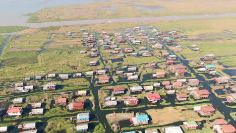 backwards drone dolley tilt shot of eain taung gyi stilt house village at inle lake in myanmar