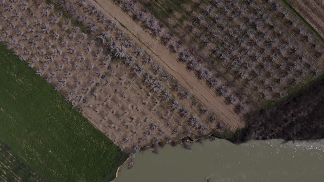 vista de drones de huertos y tierras de cultivo junto al río que fluye