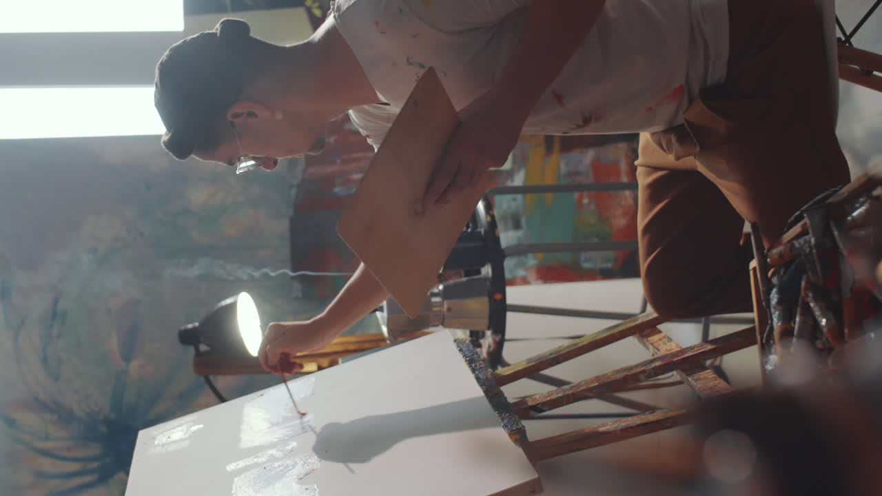 스튜디오에서 그림을 그리는 동안 브러시를 사용하는 남성 예술가