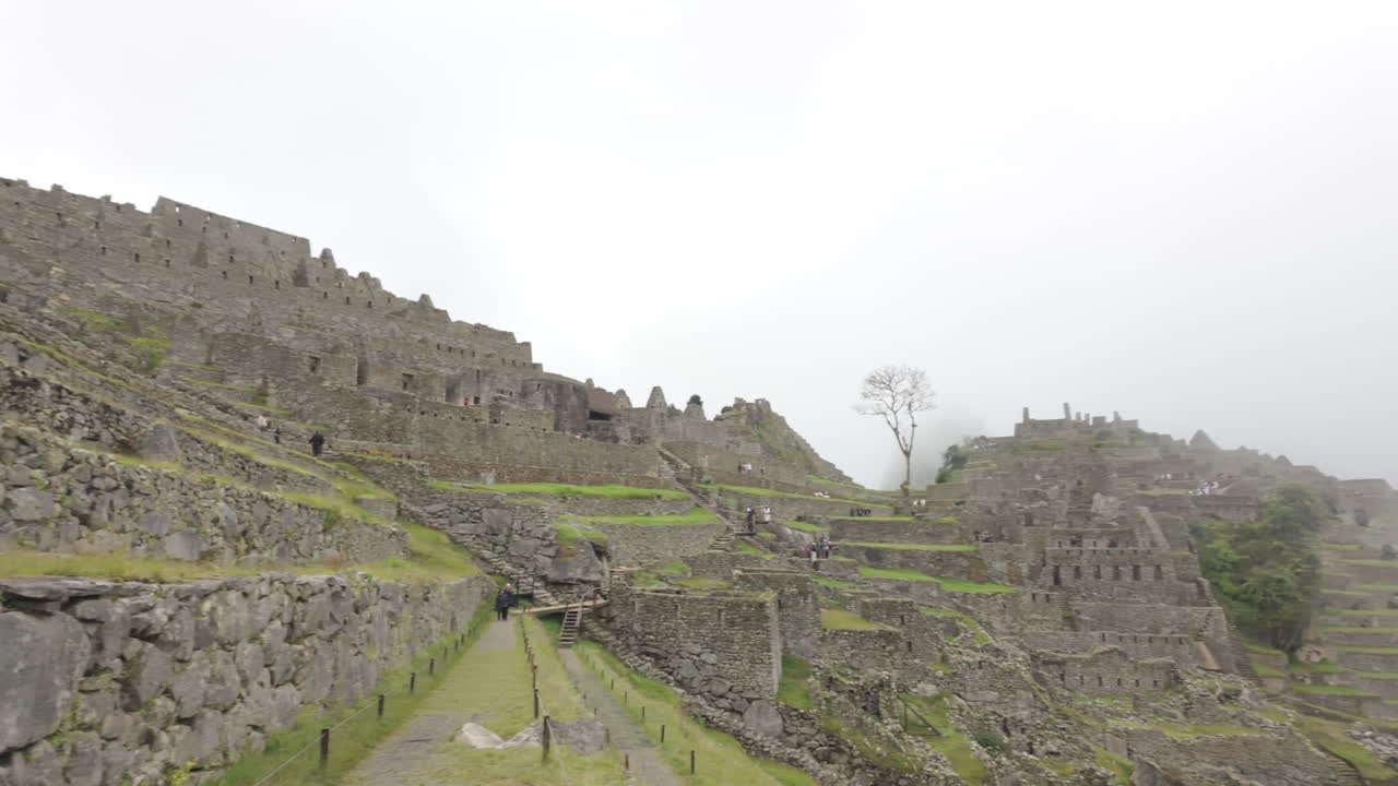 Slow motion video of Inca stone structures inside Machu Picchu, showing ancient walls and architecture in Peru