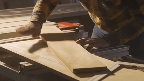 Measuring-wood-with-meter-in-carpentry-shop.