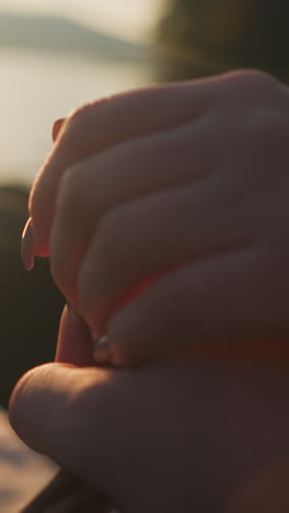 pareja de manos en la orilla del río. hombre y mujer pareja enamorada disfruta de la vista de la belleza de la naturaleza juntos al atardecer. amor y apoyo entre jóvenes