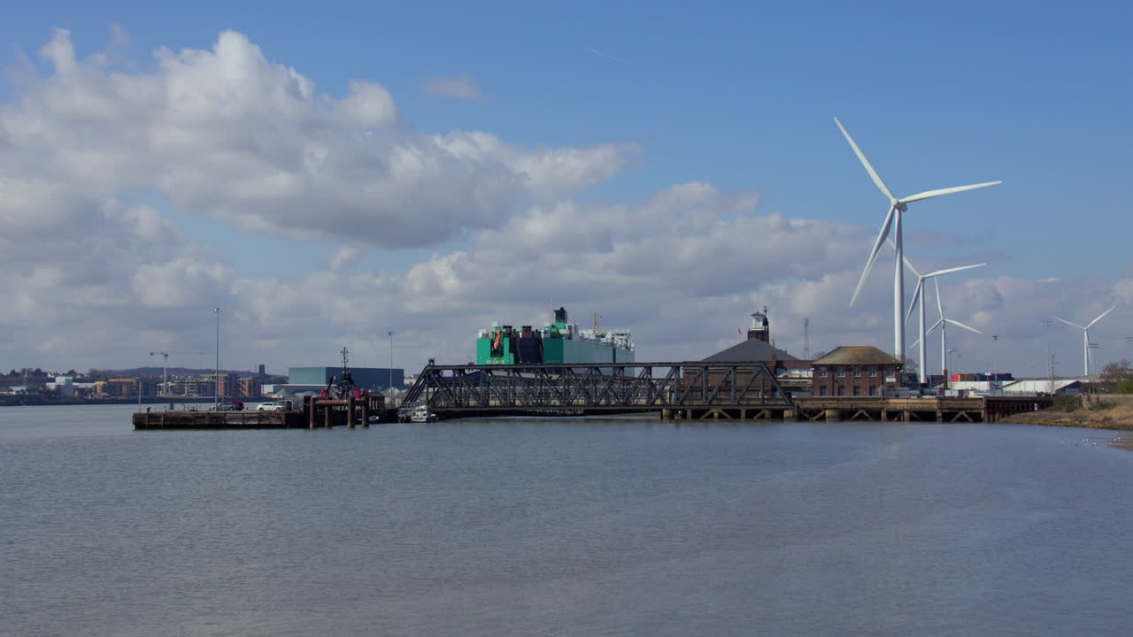 Wide shot looking at London cruise terminal with wind turbines in background