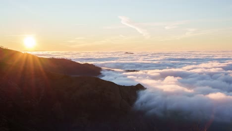 Sunrise-over-cloud-covered-hills-with-sunbeams,-in-Genoa,-Liguria,-Italy