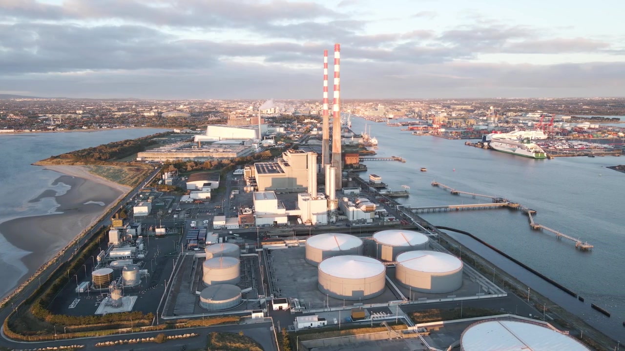 Les centrales électriques de Poolbeg et le port de Dublin vus du ciel en plein jour, par une journée partiellement nuageuse.