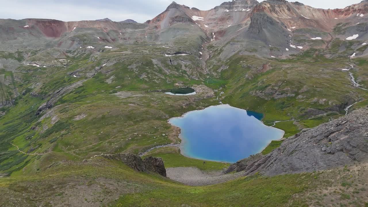 Stunning aerial drone footage captures serene blue alpine lake nestled among rocky peaks and lush green valleys in West Virginia showcasing natural beauty and remote mountain landscape