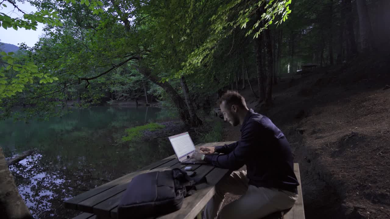 hombre de negocios exitoso trabajando con computadora portátil en la naturaleza.