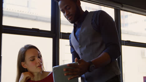 Front-view-of-young-cool-mixed-race-business-team-planning-and-working-at-desk-of-modern-office-4k