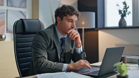 focused boss reading papers working laptop agency closeup. excited man rejoicing