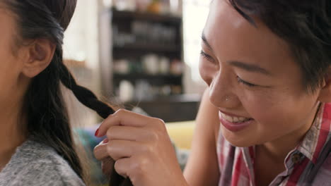 happy women friends braiding hair