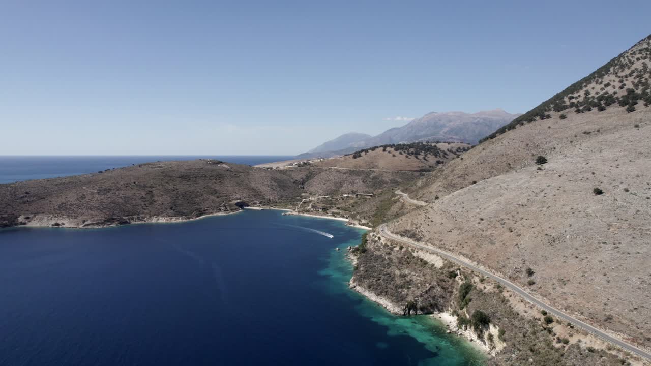 Video with a drone over the turquoise waters of the Albanian coast in Porto Palermo, you can see a submarine Bunker from the 2 World War and a boat sailing