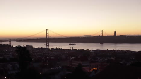 Amanecer-En-La-Ciudad-De-Lisboa-Con-Lapso-De-Tiempo-Del-Puente-Del-25-De-Abril,-Río-Y-Paseo-Marítimo-Temprano-En-La-Mañana