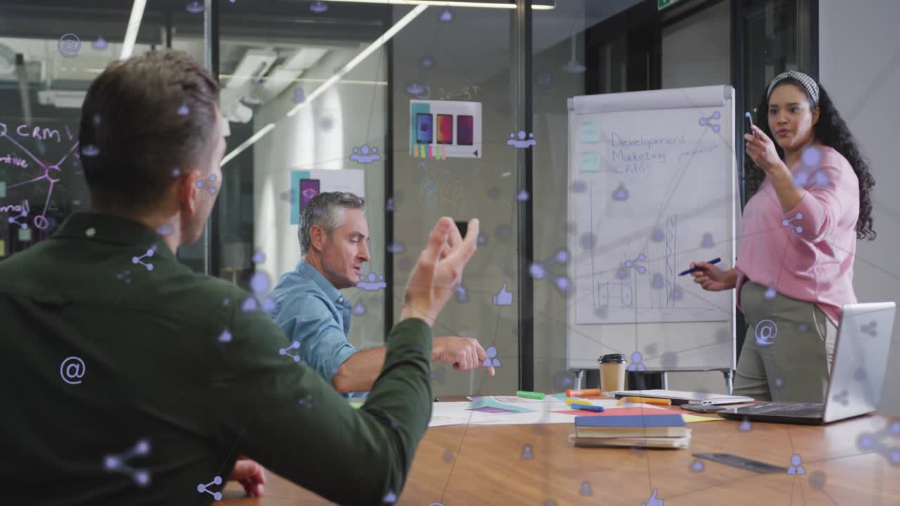 Presenter drawing marketing chart with floating social icons as colleague raising hand for insight