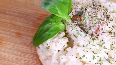 close up view of beautiful homemade risotto rotating on wood surface, macro shot in 4k