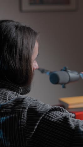 man with long hair and beard speaking into a microphone