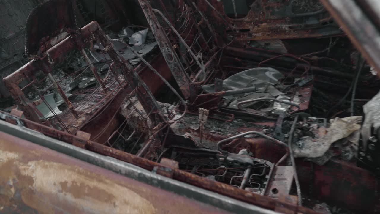 el interior del coche es un desastre de escombros y escombros después de pasar por un incendio forestal - 4k