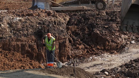 construction worker shoveling dirt on a building site