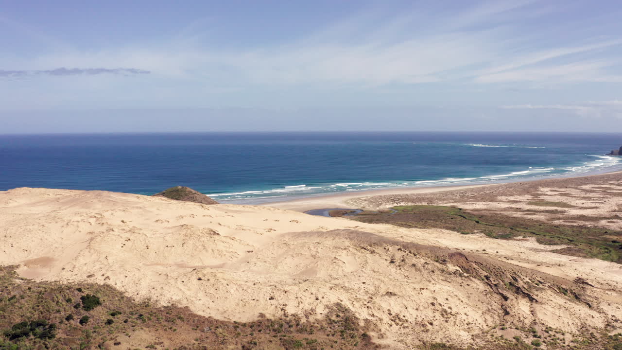 dunas de arena gigantes con mar azul y playa en verano en cabo reinga, península de aupouri en la isla norte de nueva zelanda