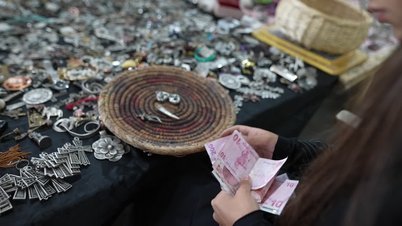 시장 에서 손으로 만든 보석 을 지불 하는 여자