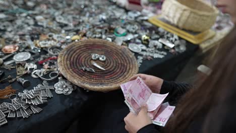mujer pagando por joyas hechas a mano en un mercado