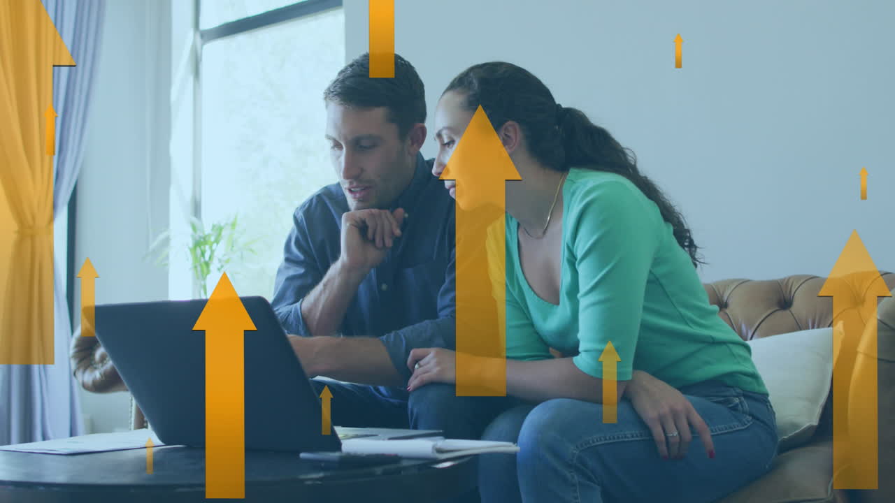 animación de iconos de flecha moviéndose hacia arriba contra pareja caucásica calculando las finanzas en casa