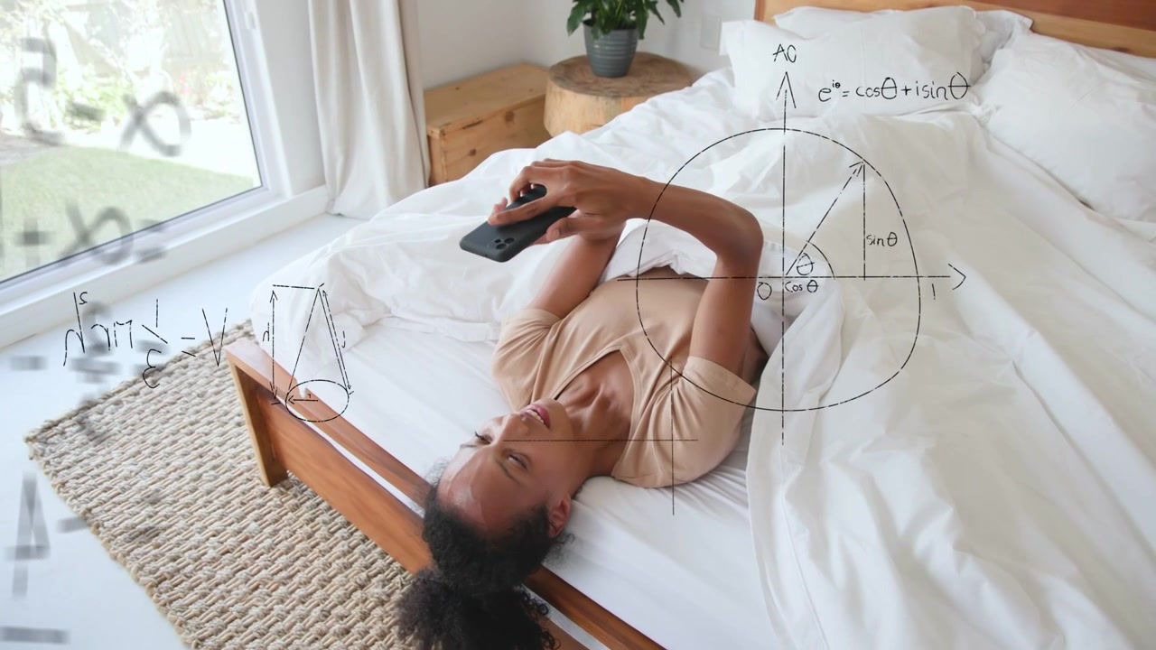 Una donna sdraiata sul letto tiene un dispositivo e studia matematica, con diagrammi animati che appaiono intorno allo schermo.