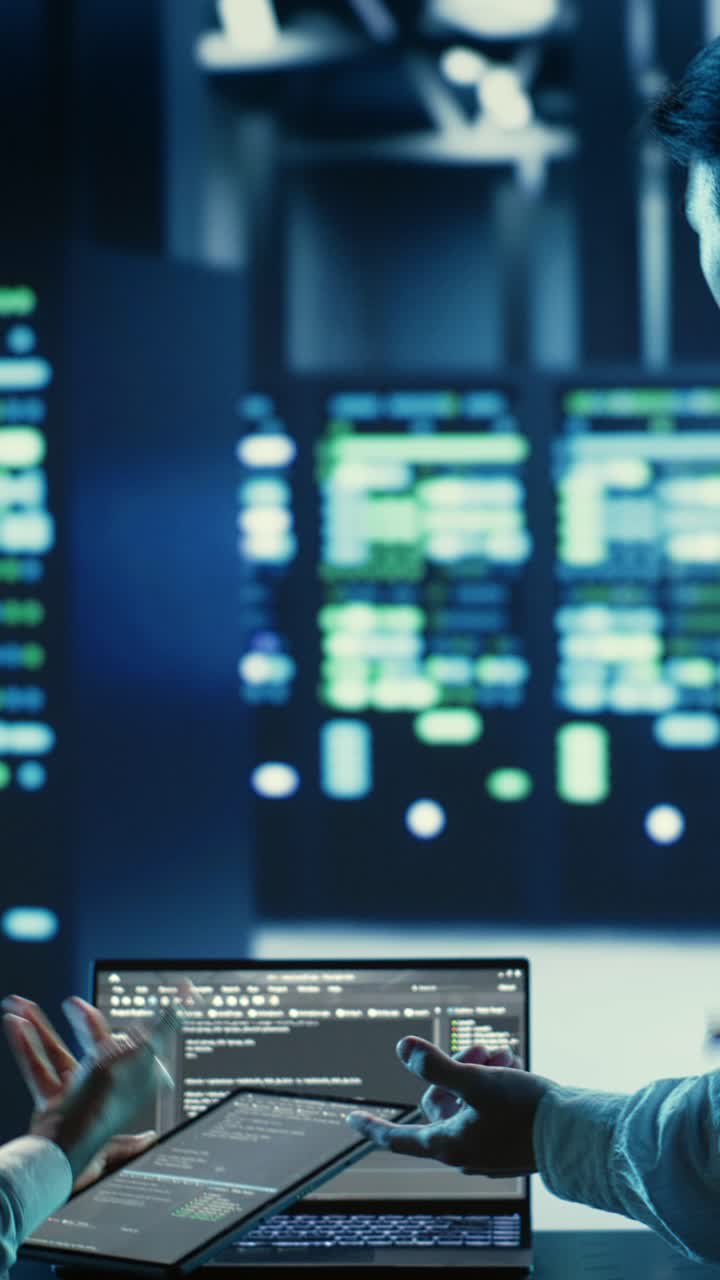 Vertical video Workers coding in data center