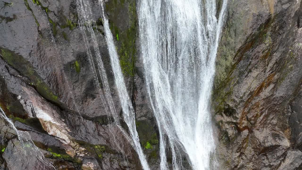 un dron captura una majestuosa cascada que cae en cascada por una escarpada montaña rocosa en inglaterra, reino unido.