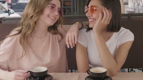 two women friends having coffee outdoors