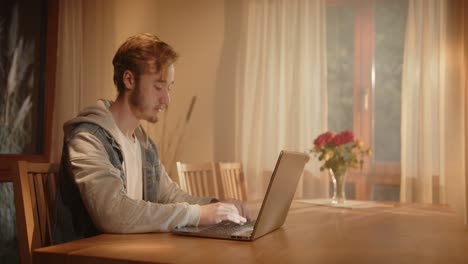 someone-is-typing-on-the-laptop-in-the-living-room-in-the-morning,-with-light-from-outside