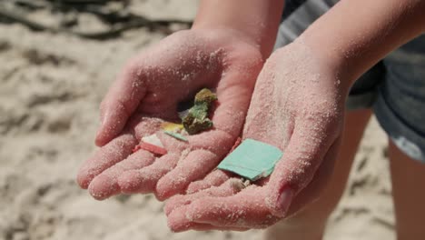 chica voluntaria sosteniendo residuos en sus manos en la playa 4k