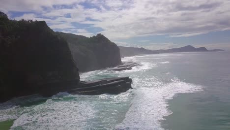 Slow-aerial-morning-flight-towards-cliffs-and-wild-colorful-ocean,-Australia