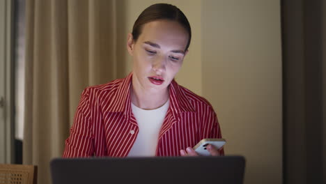 Woman browsing computer evening at home closeup. Pretty girl shopping online