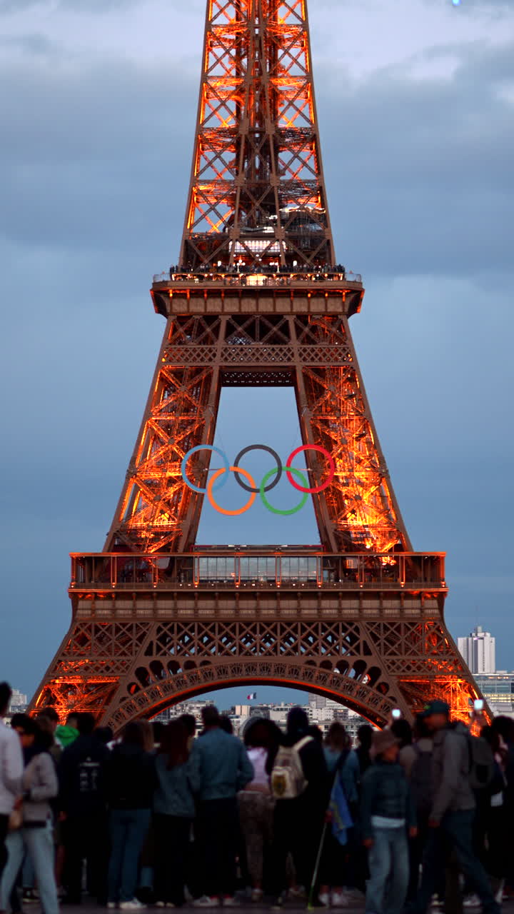 The Eiffel Tower with the Olympic Games sign sparkling in the evening in Paris, France. Vertical
