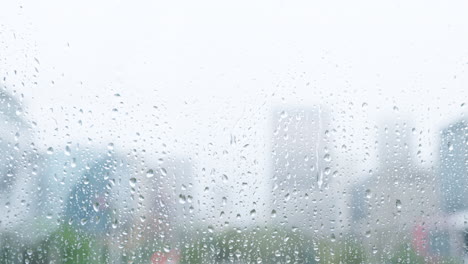 city, window with rain and water on glass